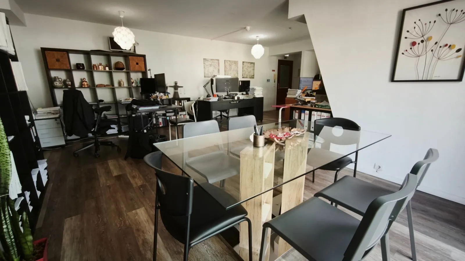 Sala do escritório com mesa de reuniões e postos de trabalho